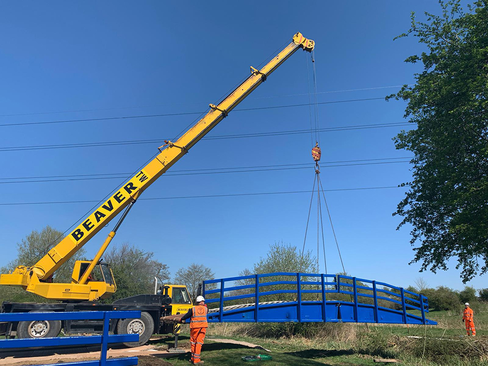 tank bridge install - crane lifting bridge into place