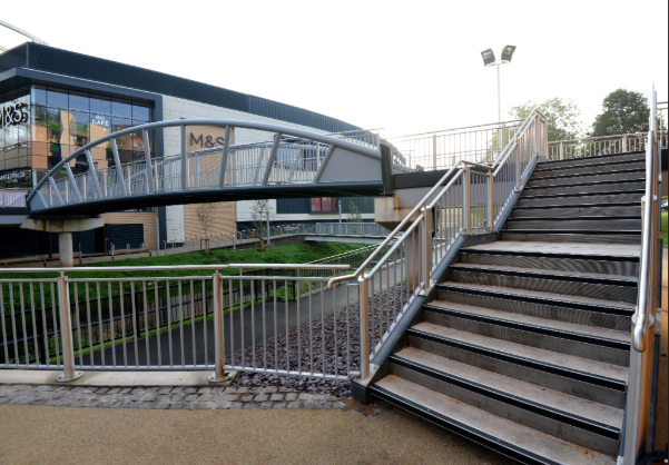 A staircase leading up to a building, featuring a bridge that spans across to an adjacent area.