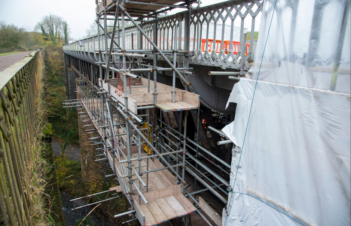 Side view of the viaduct with white environmental encapsulation used for grit blasting and painting.
