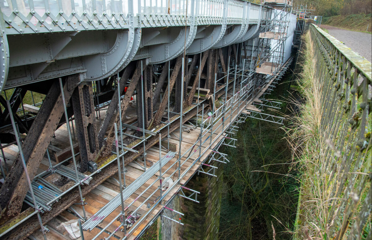 Close-up of the underside of the viaduct showing structural steelwork and specialist access scaffolding.
